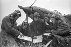 Штурман 688-го шап старший политрук М.Г. Скляров с группой летчиков полка изучает машрут перед боевым вылетом