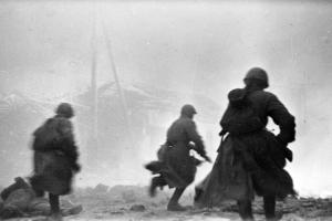 Советские пехотинцы бегут в атаку по улице Сталинграда.