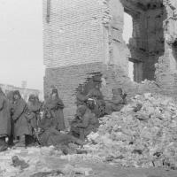 Солдаты одной из частей 64-й армии во время отдыха рядом с разрушенным зданием. Сталинград, зима 1943 года 